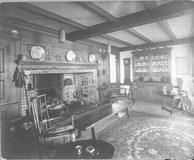 SA0519 - A room interior with fireplace, chairs, tables, metal ware, a clock, and sideboard., Winterthur Shaker Photograph and Post Card Collection 1851 to 1921c